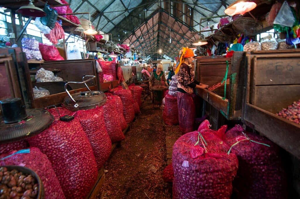 Karung-karung berisi bawang merah memenuhi lorong pasar.